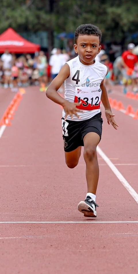 Young Quest Sports sprinter racing on an outdoor track